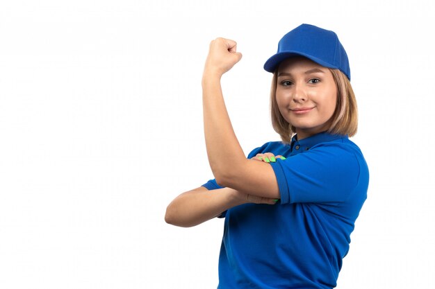 A front view young female courier in blue uniform just posing and flexing