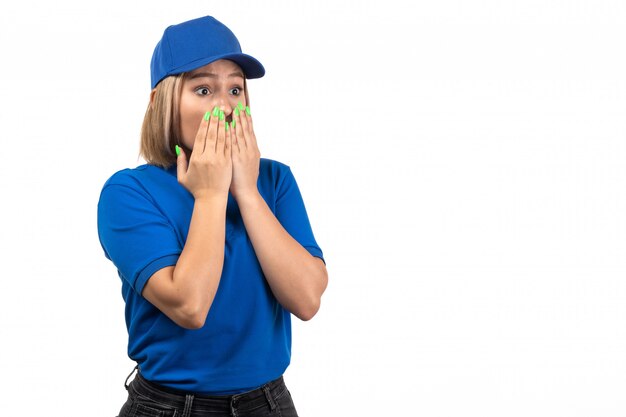 A front view young female courier in blue uniform just posing with scared expression