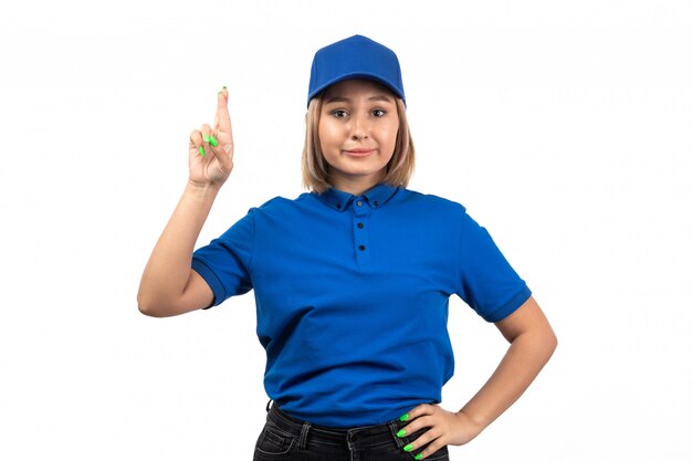 A front view young female courier in blue uniform just posing