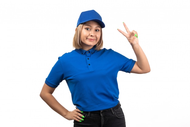 A front view young female courier in blue uniform just posing