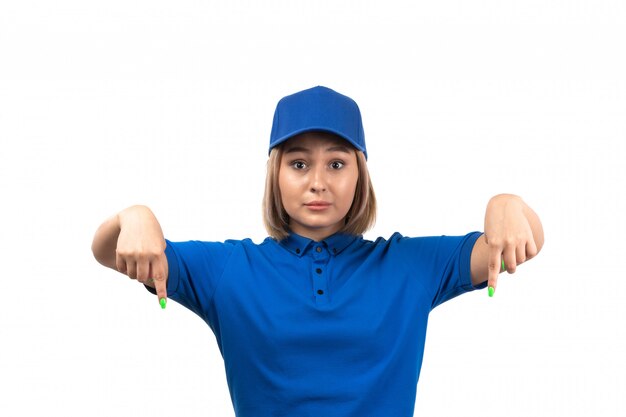 A front view young female courier in blue uniform just posing