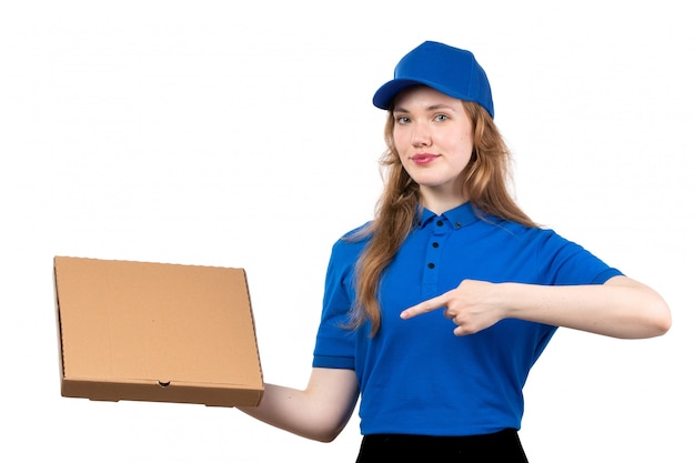 A front view young female courier female worker of food delivery service holding food delivery package smiling on white