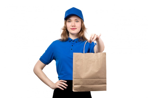 Вид спереди молодая женщина курьер работница службы доставки еды, холдинг пакет доставки еды, улыбаясь на белом