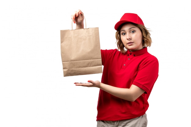 A front view young female courier female worker of food delivery service holding food delivery package on white