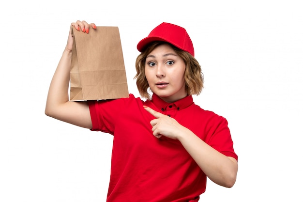 A front view young female courier female worker of food delivery service holding food delivery package on white