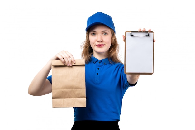 白に笑みを浮かべてメモ帳と食品パッケージを保持している食品配達サービスの正面の若い女性宅配便女性労働者