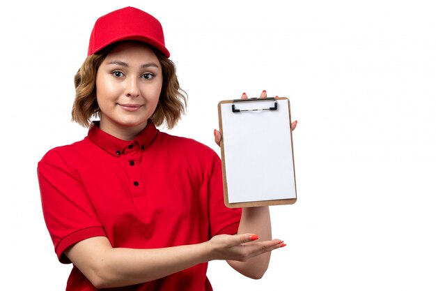 Foto gratuita una lavoratrice femminile del giovane corriere femminile di vista frontale del blocco note della tenuta di servizio di distribuzione di alimenti per le firme che sorride sul bianco