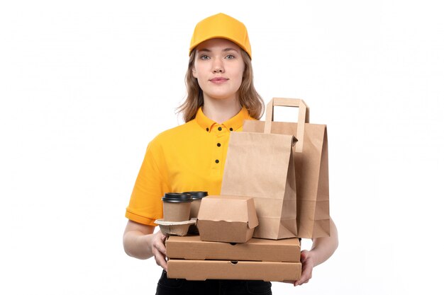 Вид спереди молодой женщины курьер работница службы доставки еды, холдинг коробки для пиццы и пакеты с едой на белом