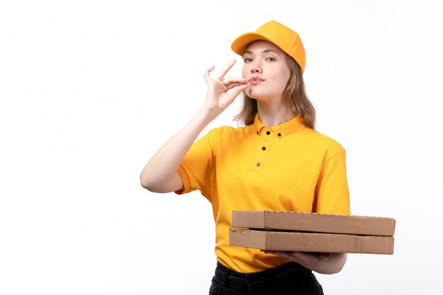 A front view young female courier female worker of food delivery service holding pizza boxes showing tasty sign on white