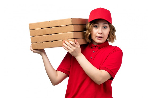 Вид спереди молодой женщины курьер работница службы доставки еды, холдинг коробки для пиццы на белом