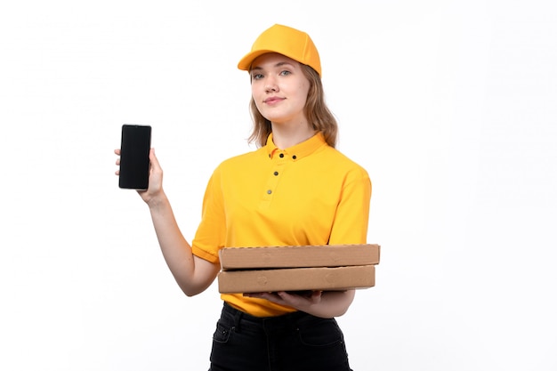 A front view young female courier female worker of food delivery service holding smartphone and pizza boxes on white