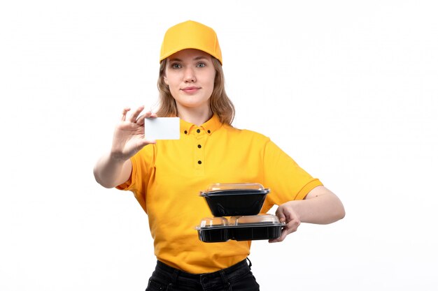 A front view young female courier female worker of food delivery service holding white card and bowls with food on white