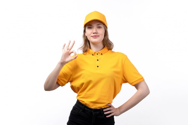 A front view young female courier female worker of food delivery service posing with alright sign smiling on white