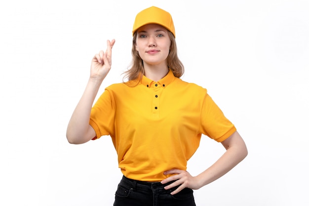 A front view young female courier female worker of food delivery service showing crossed fingers smiling on white