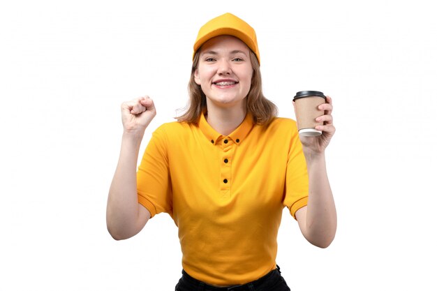 Вид спереди молодой женщины курьер работница службы доставки еды, улыбаясь и наслаждаясь, держа чашку с кофе на белом