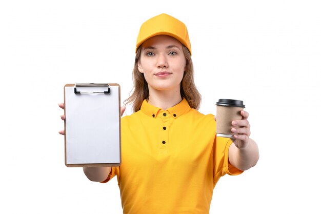 A front view young female courier female worker of food delivery service smiling holding cup with coffee and notepad for signature on white