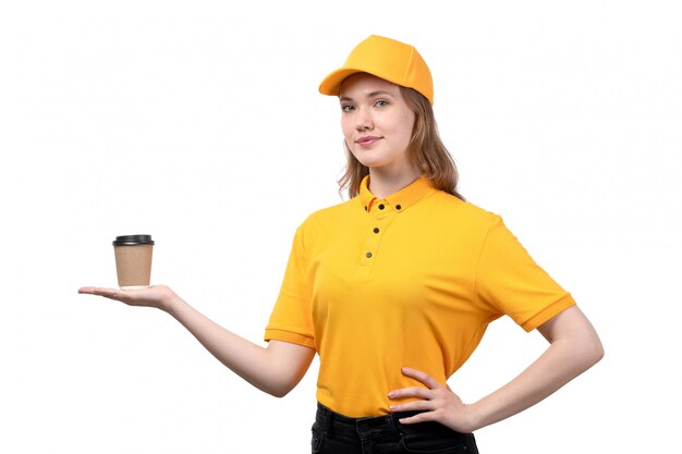 A front view young female courier female worker of food delivery service smiling holding cup with coffee on white