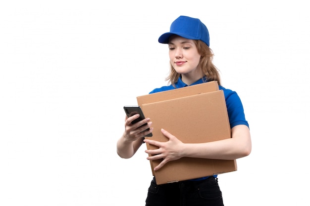 A front view young female courier female worker of food delivery service smiling holding delivery boxes on white