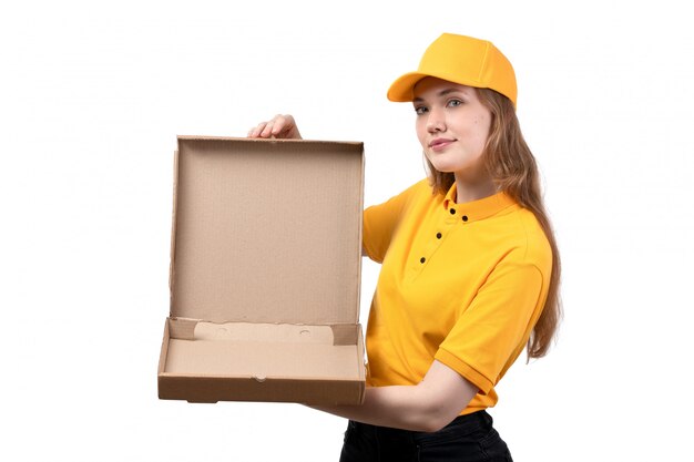 Вид спереди молодая женщина курьер работница службы доставки еды, улыбаясь, держа пустую коробку от пиццы на белом