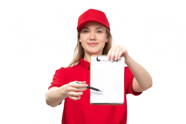 A front view young female courier female worker of food delivery service smiling holding notepad and asking for the signature on white