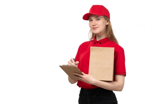 A front view young female courier female worker of food delivery service smiling holding notepad on white