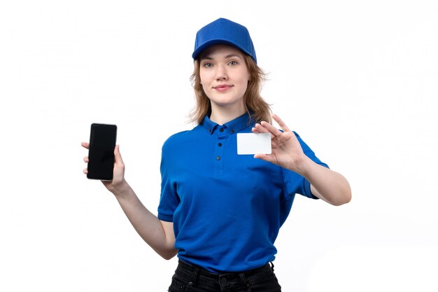 A front view young female courier female worker of food delivery service smiling holding white card and smartphone on white