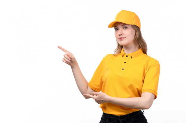 A front view young female courier female worker of food delivery service smiling pointing out with her fingers on white
