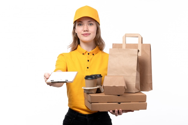 A front view young female courier female worker of food delivery service smiling while holding coffee cups food packages on white