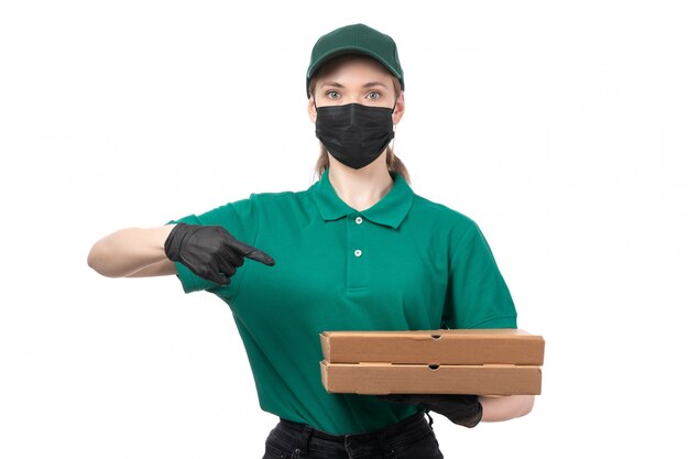 緑の制服の黒い手袋と食品配達箱を持って黒いマスクの正面の若い女性の宅配便