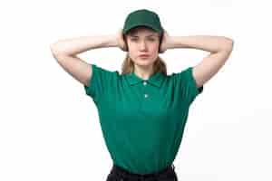 Free photo a front view young female courier in green uniform covering her ears posing on white