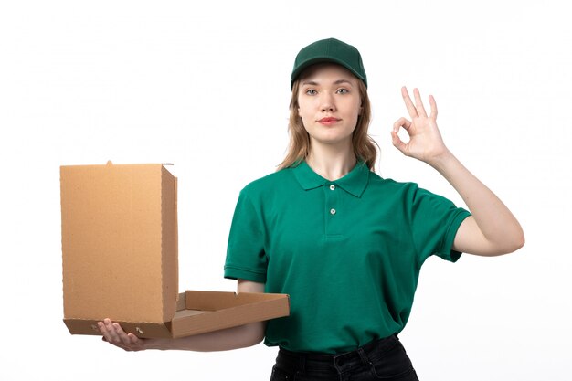 Молодая женщина-курьер в зеленой форме, держащая пакет для доставки еды, вид спереди