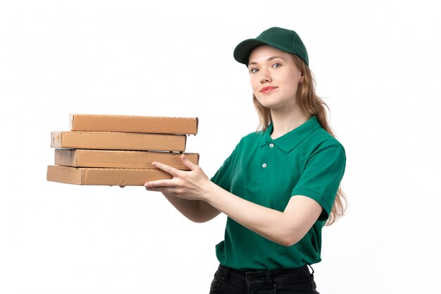 A front view young female courier in green uniform holding pizza boxes