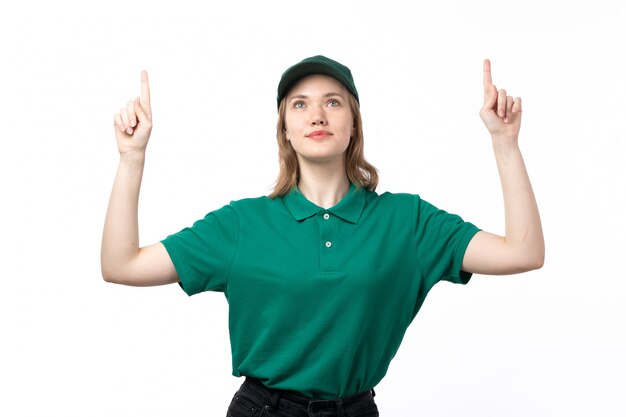 A front view young female courier in green uniform looking above smiling