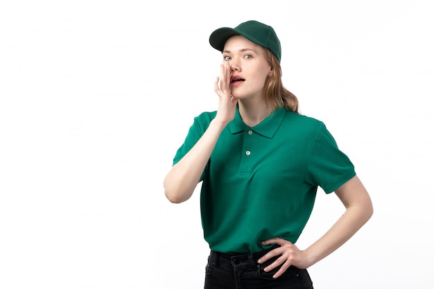 Вид спереди молодая женщина-курьер в зеленой форме позирует и шепчет