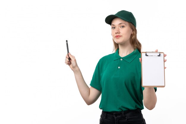 A front view young female courier in green uniform smiling holding pen and notepad