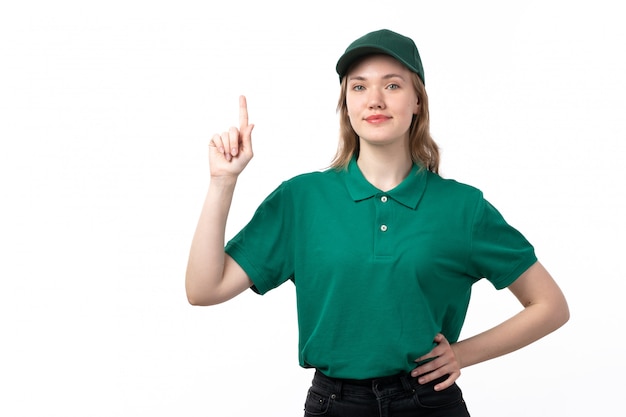 A front view young female courier in green uniform smiling posing with raised finger