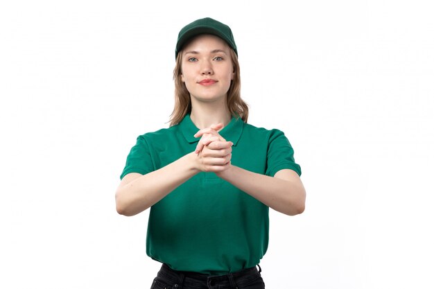 A front view young female courier in green uniform smiling shaking her hands