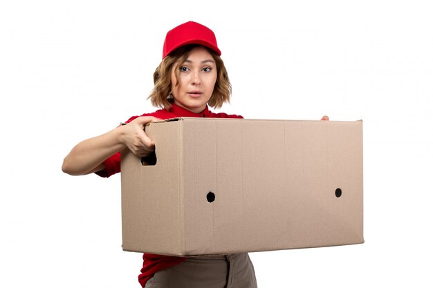 Молодая женщина-курьер в форме, держащая большую коробку для доставки, вид спереди