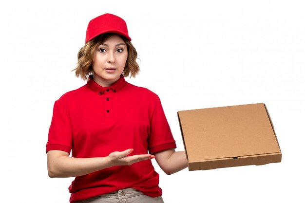 A front view young female courier in uniform holding delivery package