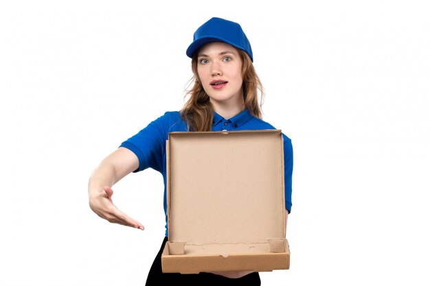 A front view young female courier in uniform holding an empty pizza box