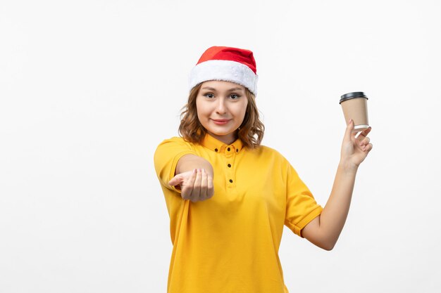 Front view young female courier with coffee on the white wall uniform service delivery