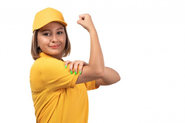 A front view young female courier in yellow uniform posing and flexing