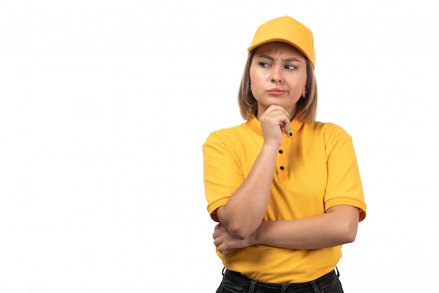 A front view young female courier in yellow uniform thinking