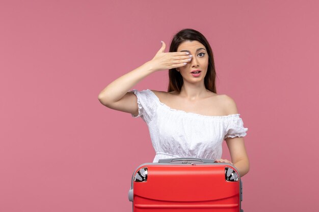 Front view young female covering half of her face on pink background abroad sea journey voyage travel trip