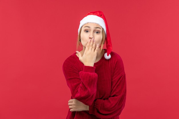 Front view young female covering her mouth, red holiday christmas