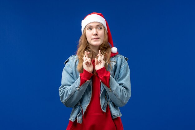 Front view young female crossing her fingers on blue background new year holiday christmas