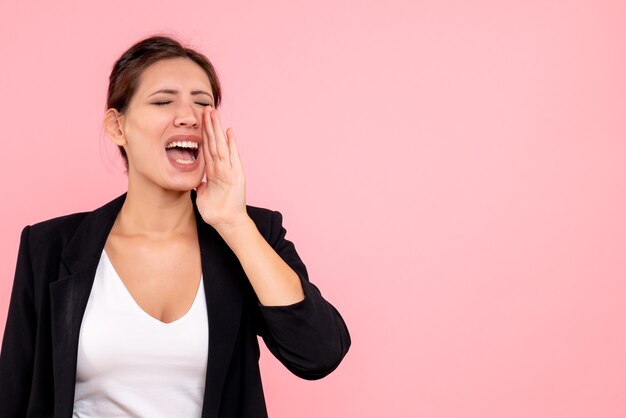 Front view young female in dark jacket loudly calling on pink background