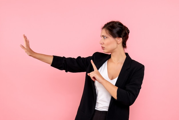 Foto gratuita vista frontale giovane femmina in giacca scura su sfondo rosa