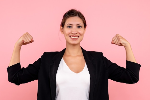 Free photo front view young female in dark jacket smiling and flexing on pink background