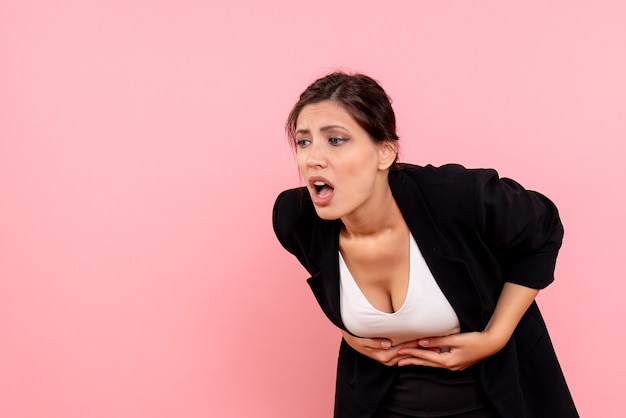 Free photo front view young female in dark jacket suffering from stomachache on pink background